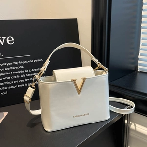 Elegant white leather handbag with gold V-metal decor and adjustable shoulder strap