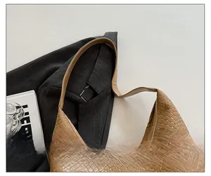 Detail of comfortable shoulder strap on brown woven tote bag with 3D braided texture