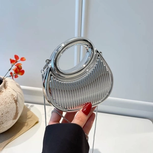 Metallic silver hardshell evening clutch with vertical ridges and round cutout handle