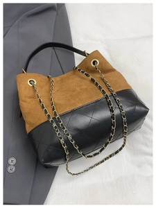 Detail of color-block bucket bag with brown suede and black quilted leather textures