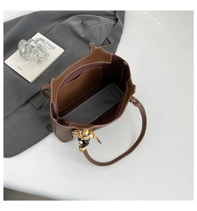 Interior detail of a brown tote bag with contrast stitching and decorative silk scarf
