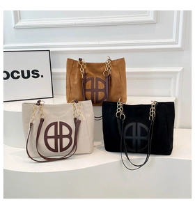 Tres bolsos tote de ante en marrón, crema y negro con elegantes correas de cadena oro