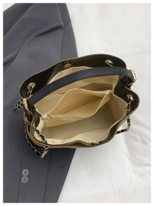 Detail of suede bucket bag interior showing spacious main compartment and zip pocket