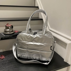 Silver quilted tote bag with large capacity and detachable strap on indoor steps