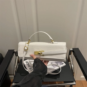 White faux leather baguette bag with crocodile pattern and golden turn-lock closure