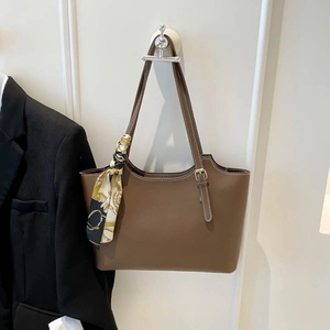 Brown vintage leather bucket tote bag with decorative silk scarf and white stitching