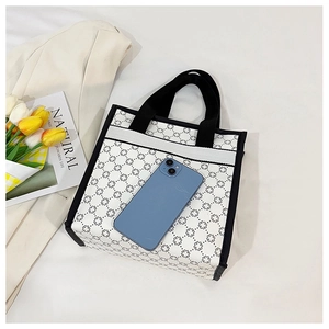 Vertical canvas tote bag with geometric cross pattern and phone for size reference