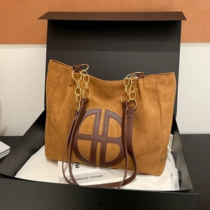 Sac tote en daim caramel avec bandoulière chaîne présenté dans une boîte cadeau de luxe