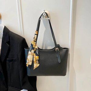 Classic black faux leather tote bag with white contrast stitching and decorative silk scarf