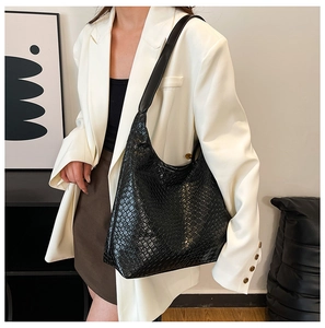 Detail of the high-quality woven texture on a large black PU leather tote bag