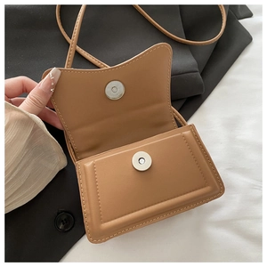 Detail of tan PU leather crossbody bag with silver magnetic snap and neat stitching