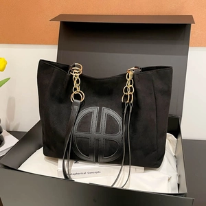 Sac cabas en daim noir avec bandoulière chaîne et logo dans un coffret cadeau chic