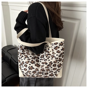 Detail of vintage leopard print tote bag with cream leather trim and shoulder strap