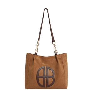 Bolso tote grande de ante marrón con correa de cadena metálica y logo circular