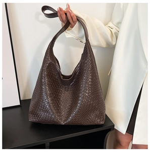 Detail of dark brown woven leather tote showing intricate texture and large hobo capacity