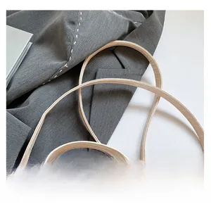 Close-up of double straps and gold hardware on beige crocodile pattern bucket bag