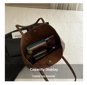 Intérieur spacieux du sac cabas marron contenant des livres et un parapluie pour le travail