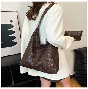 Detail of dark brown woven leather hobo tote bag with a matching small clutch pouch