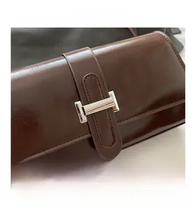 Detailed macro view of dark coffee leather texture and silver rectangular metal buckle