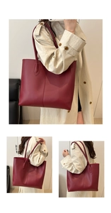 Close-up of a large dark red leather tote bag with vertical stitching and long straps