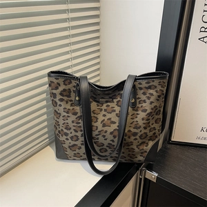 Large capacity leopard print tote bag with black handles in a modern minimalist setting