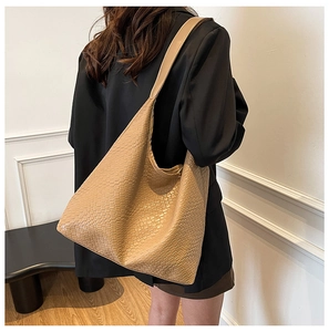 Close-up of khaki woven texture tote bag showing premium faux leather and sleek shoulder strap