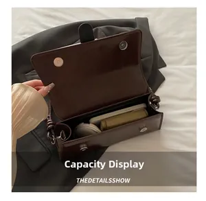 Detailed view of the spacious inner compartment of this vintage dark brown crossbody bag