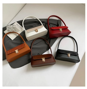 Detail view of five colors of vintage faux crocodile skin flap underarm bags with gold buckles