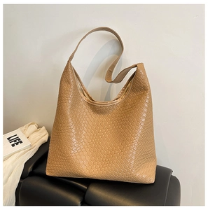 Detailed close-up of camel woven leather texture on a large hobo tote bag for women