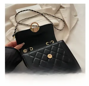 Close-up of black quilted crossbody bag with luxury gold magnetic buckle and fine texture