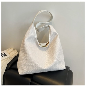 Close-up of white woven tote bag showing large capacity and golden magnetic closure