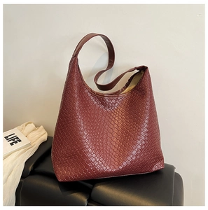 Detailed close-up of dark red woven texture and high-quality leather finish on a hobo tote bag