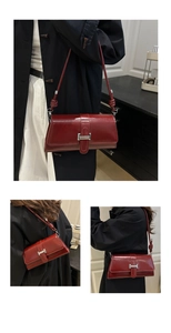 Detail view of burgundy leather shoulder bag with silver buckle and knotted strap