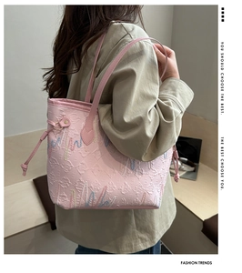 Dettaglio della borsa tote rosa con motivo di lettere, ricami e tracolla in pelle