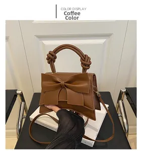 Detail of coffee brown leather handbag with large bow decoration and knotted handle