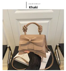 Detail of khaki crossbody bag with large leather bow decoration and knotted handle