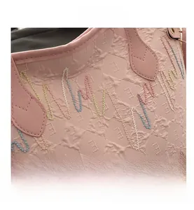 Dettaglio borsa tote rosa con goffratura di lettere e ricami a linee ondulate colorate