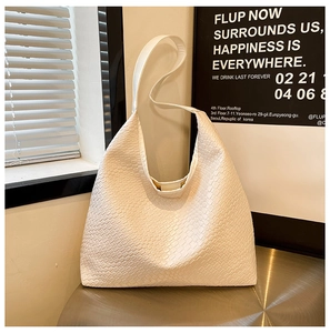 Detail of white woven leather texture on a large hobo shoulder bag over metal stand