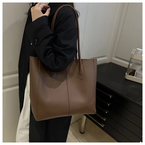 Detailed view of dark brown minimalist tote bag featuring premium leather texture and stitching