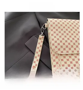 Detail of beige flap bag with red vintage patterns and metallic lobster clasp hooks
