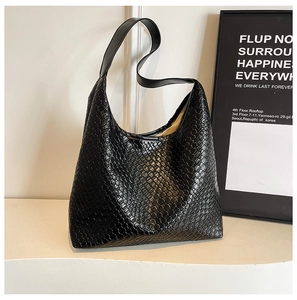 Close-up of black woven leather tote bag texture on a white display stand