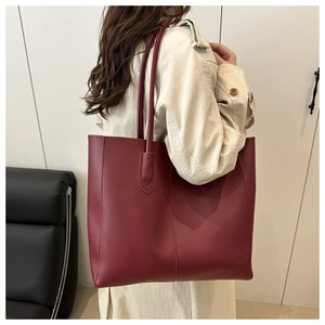 Mannequin portant un grand sac cabas en cuir bordeaux avec coutures verticales pour le travail