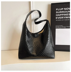 Close-up of the black woven leather texture and spacious interior of the tote bag