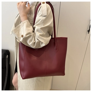 Detail of burgundy leather tote bag showing fine vertical stitching and matte texture
