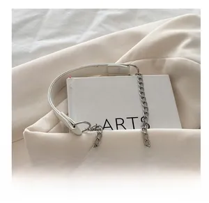 Detail of the elegant beige shoulder bag with a stylish leather and metal chain strap