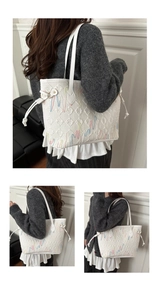 Dettaglio borsa tote trapuntata bianca con ricamo a onde colorate e finiture dorate
