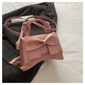 Détail d'un sac à main rose en cuir PU avec un grand nœud 3D et une poignée nouée