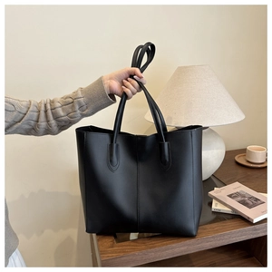 Détail du grand sac cabas noir en similicuir avec coutures verticales élégantes