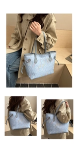 Dettaglio della borsa tote azzurra con goffratura geometrica e ricami a onde colorate