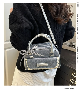 Detail of blue denim bowling bag featuring white lace trim and bow knot accessories
